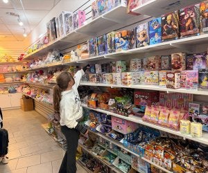 girl reaching for shelf item at asian store